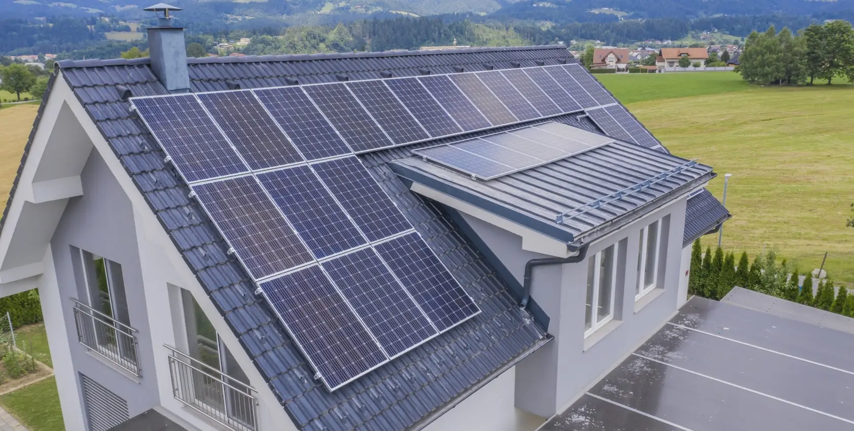 Vue aérienne d'une maison avec toiture en ardoise équipée de panneaux solaires – réalisation Altitude